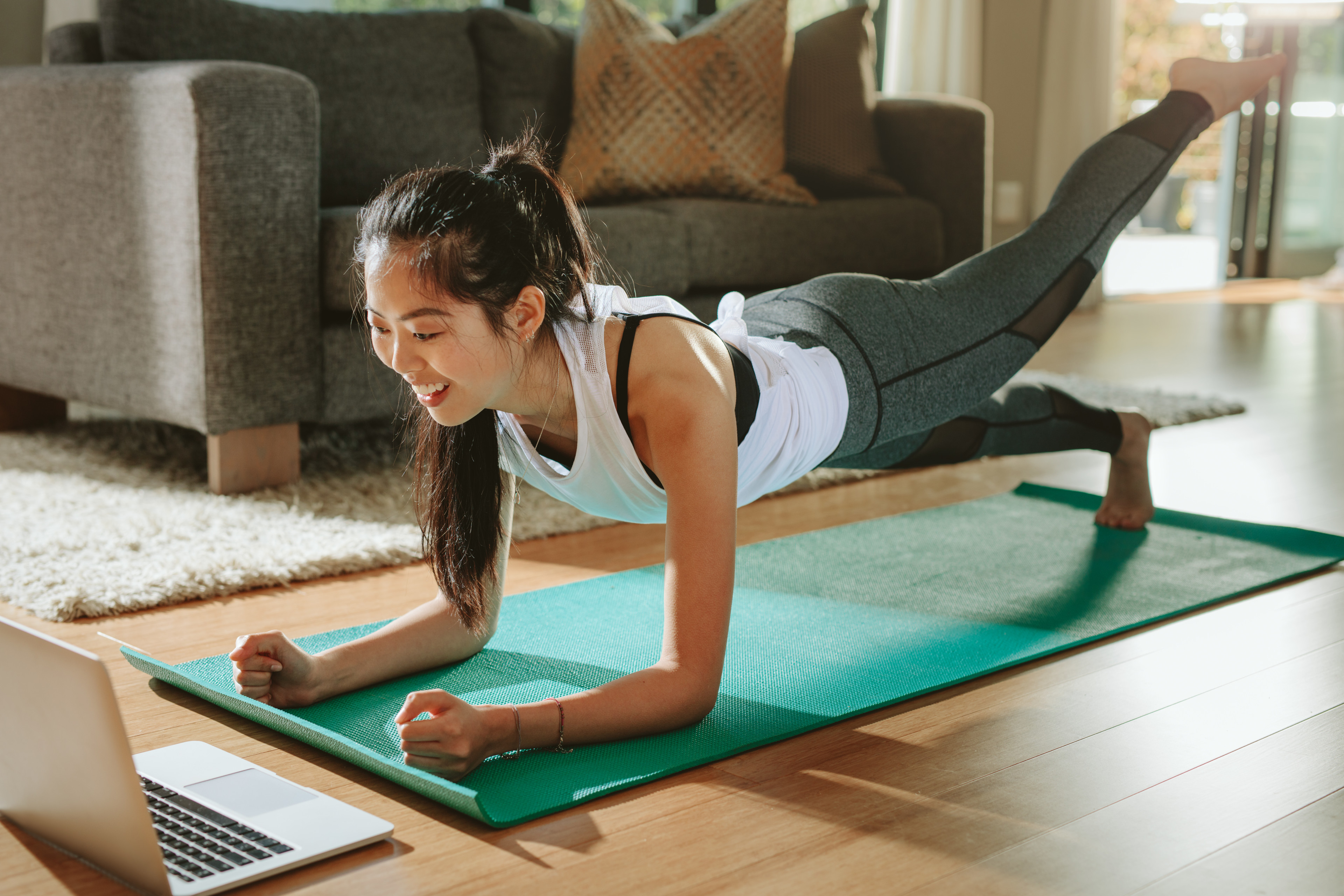 Woman practices a forearm plank at home 