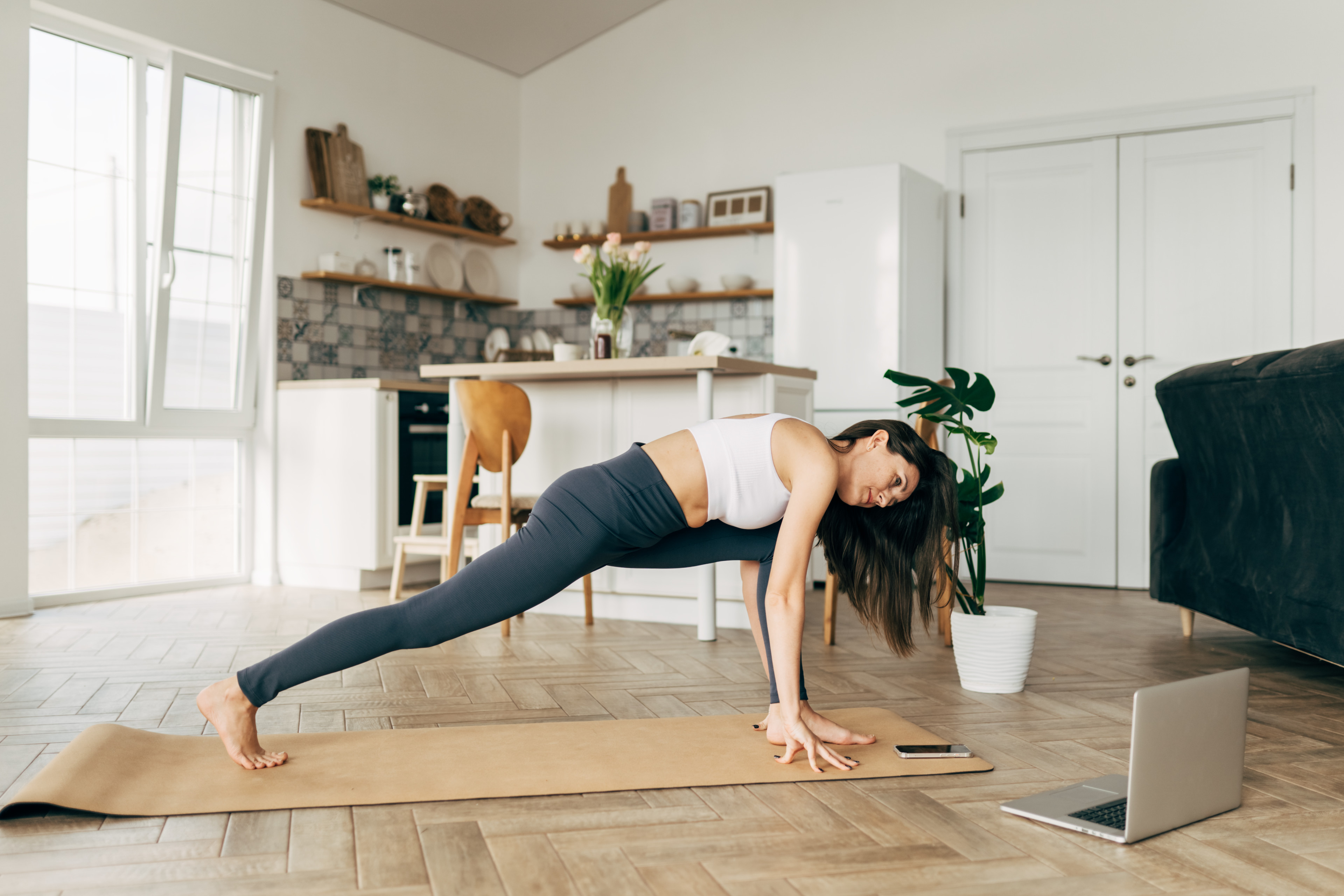 Woman practices Pilates class at home 