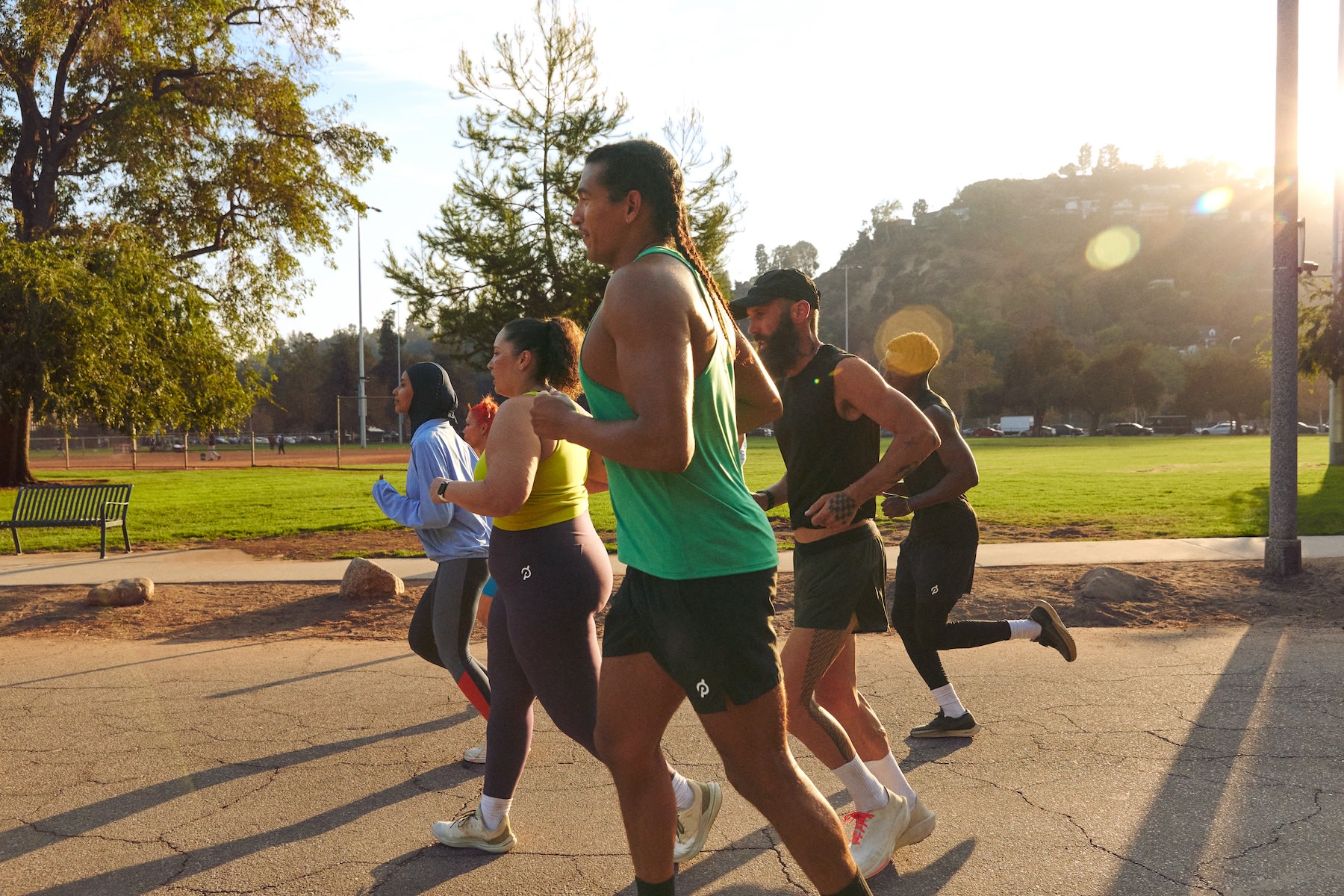 A local fitness club going for an outdoor run together at a park.