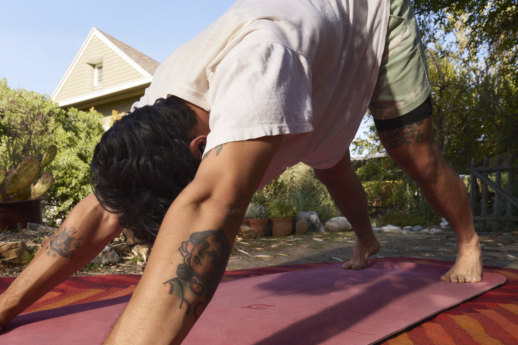 A man doing downward dog pose in yoga. Yoga is a form of mindful movement.