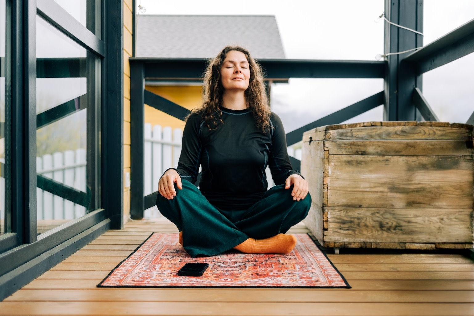 A woman in an upright seated position meditating outside. She is sitting upright to prevent herself from falling asleep during meditation.