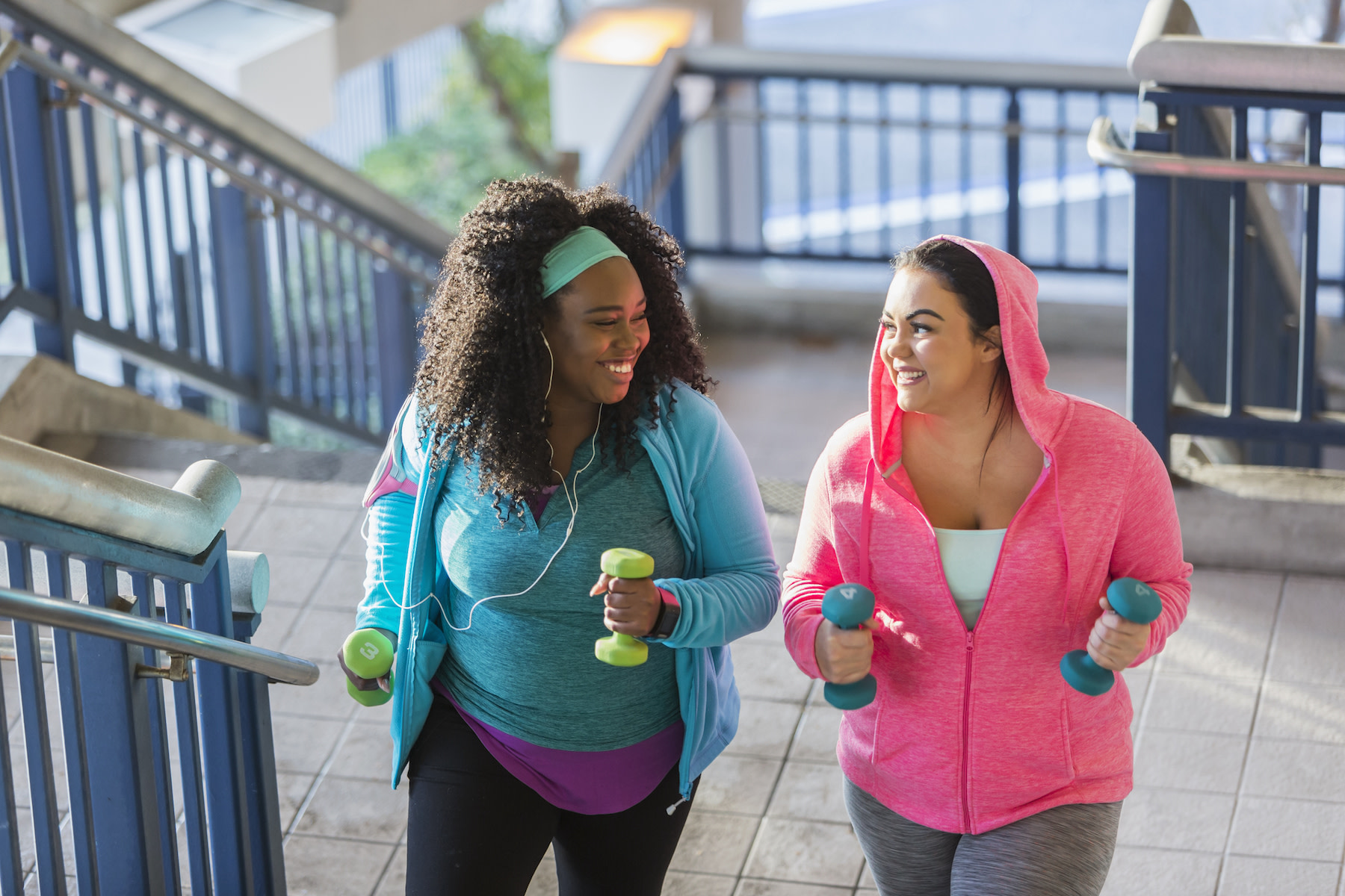 women walking with hand weights