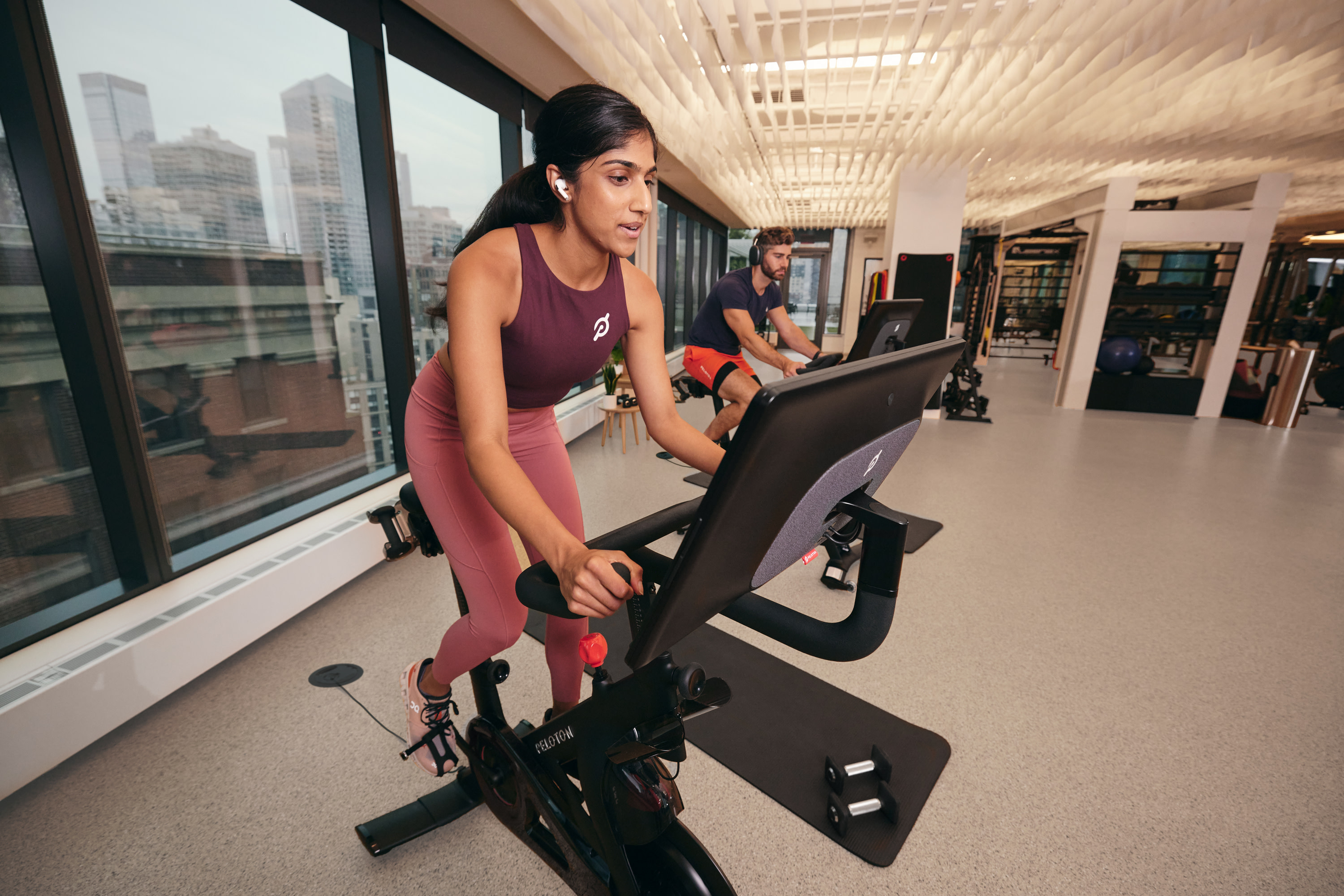 2 exercisers using the Peloton Bikes