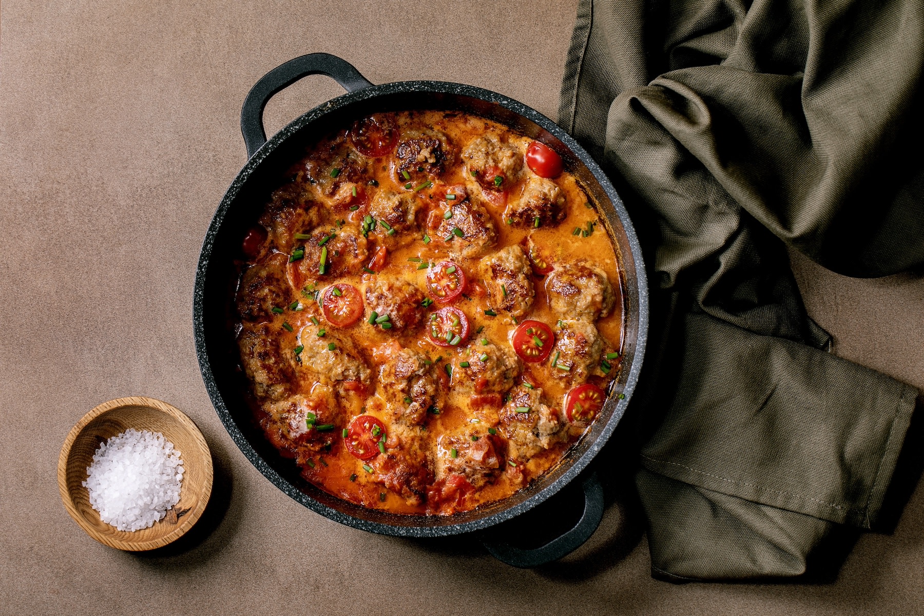 Meatballs made with ground chicken (a lean protein) in a tomato sauce in a pan.