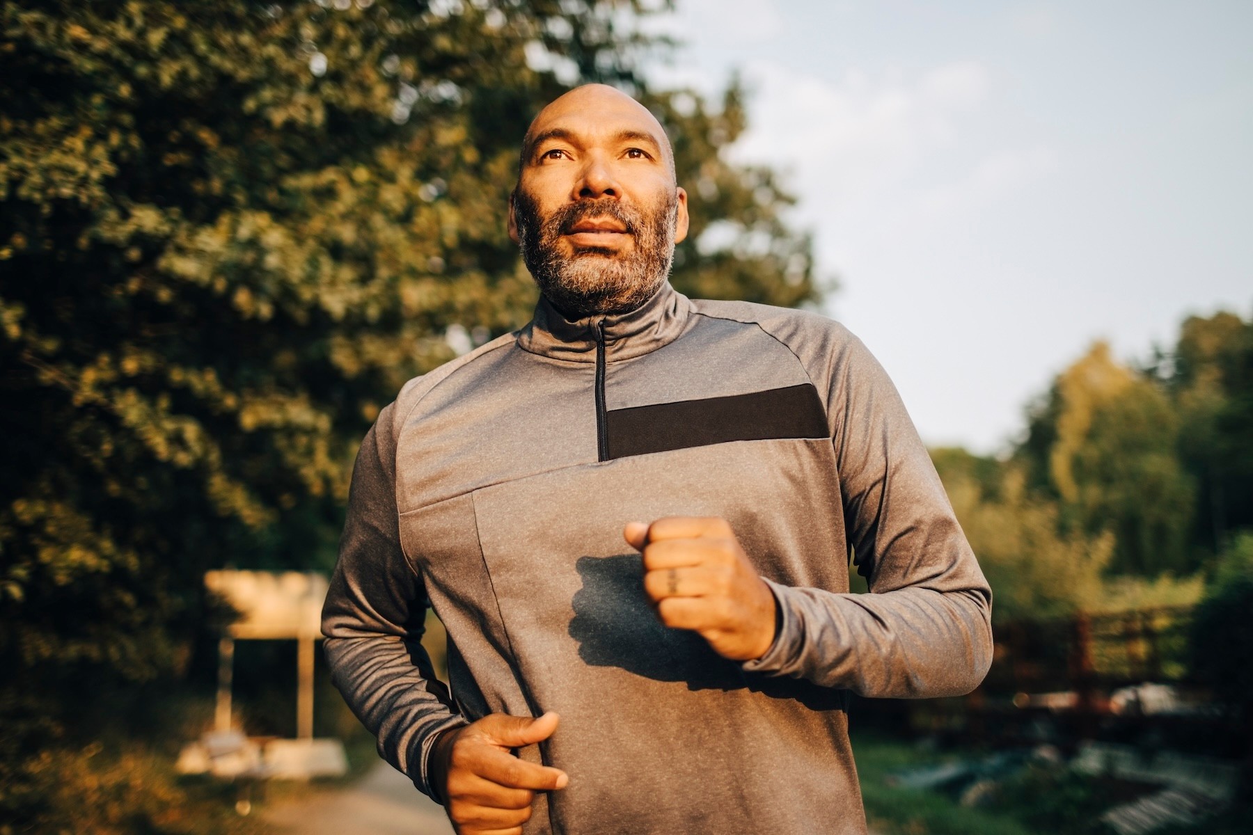 A middle-aged man going for a run outside in the morning.