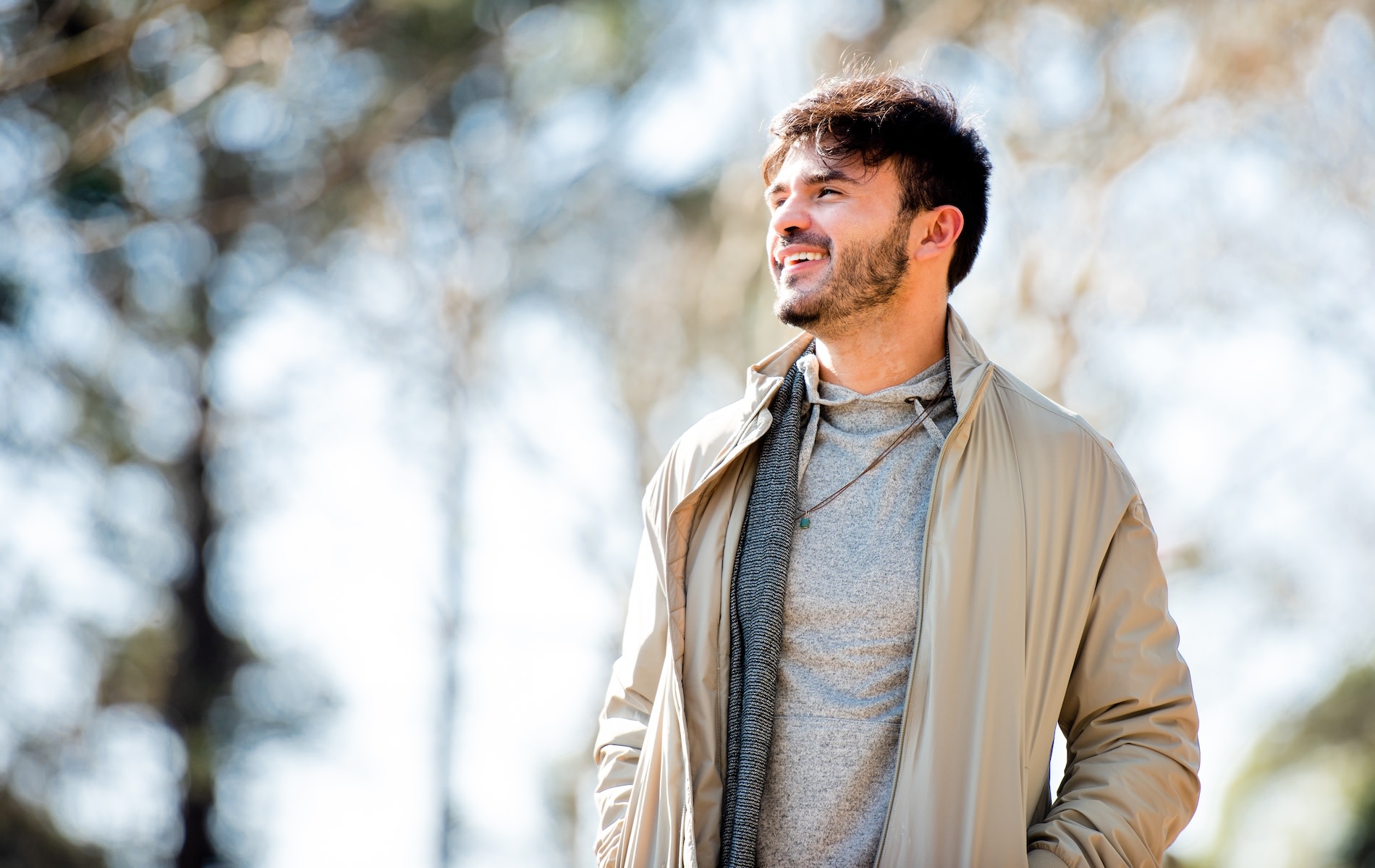 A smiling man going on a walk outside, which is a great self-care idea.