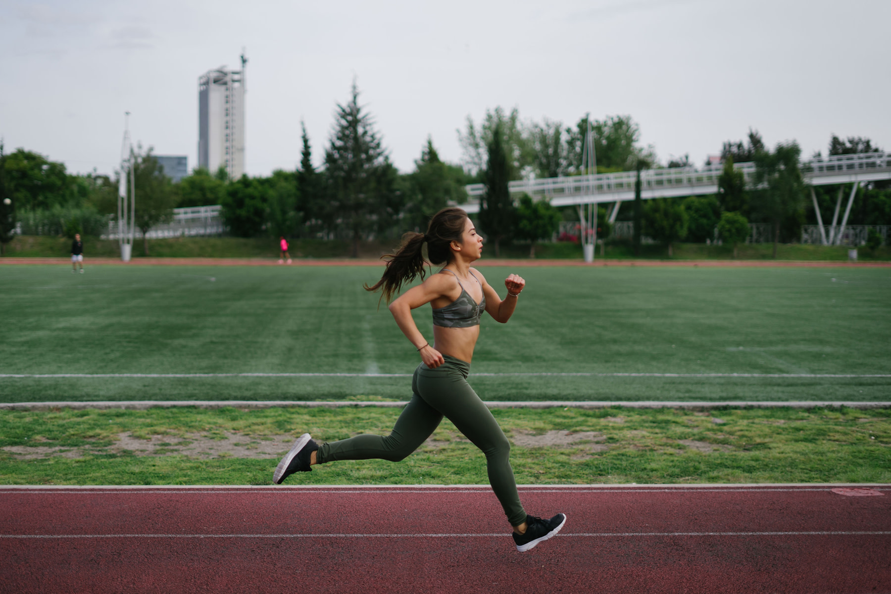 Woman runs outside on a track, how to increase vo2 max