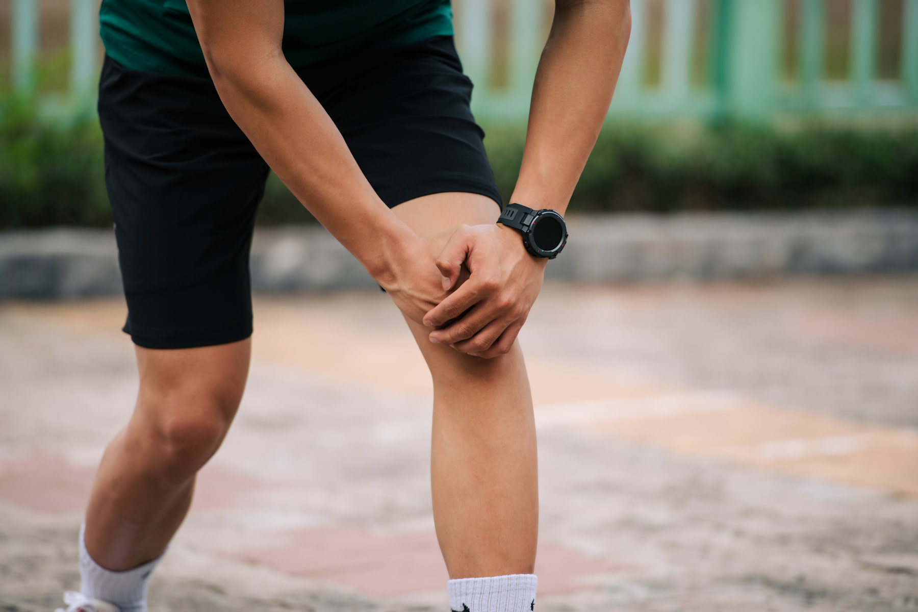 Is running bad for your knees? Man holds his knee while pausing during a run