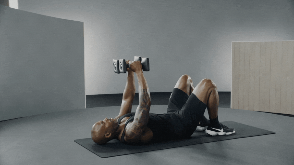 Adrian Williams demonstrates a chest fly exercise with dumbbells
