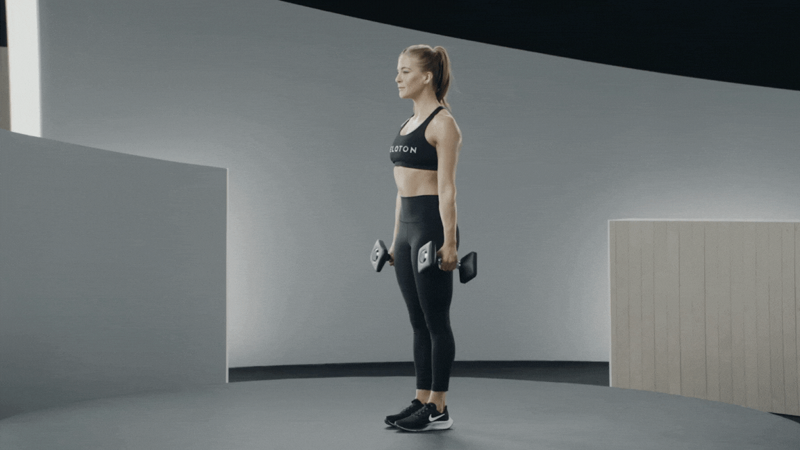 Peloton instructor Rebecca Kennedy demonstrates a staggered-stance or kickstand deadlift with dumbbells