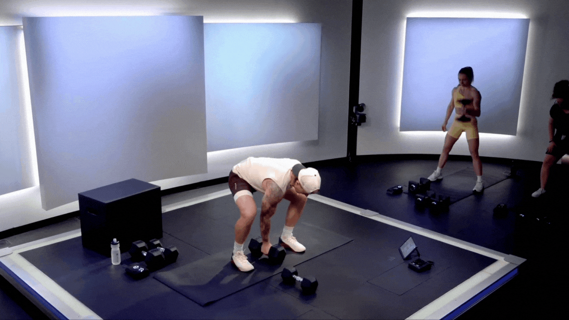 Peloton instructor demonstrates a dumbbell snatch during a strength class