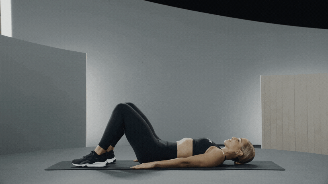 Peloton instructor Jess Sims demonstrates a glute bridge hamstring exercise
