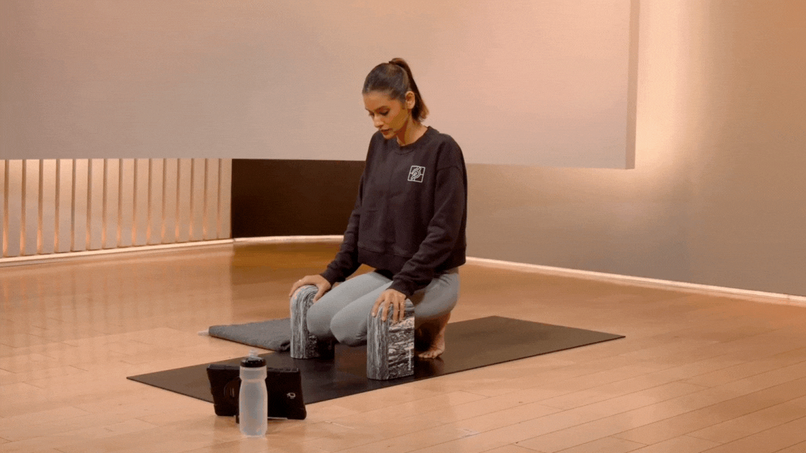 Peloton instructor Aditi Shah demonstrates a kneeling foot stretch during a Peloton yoga class.