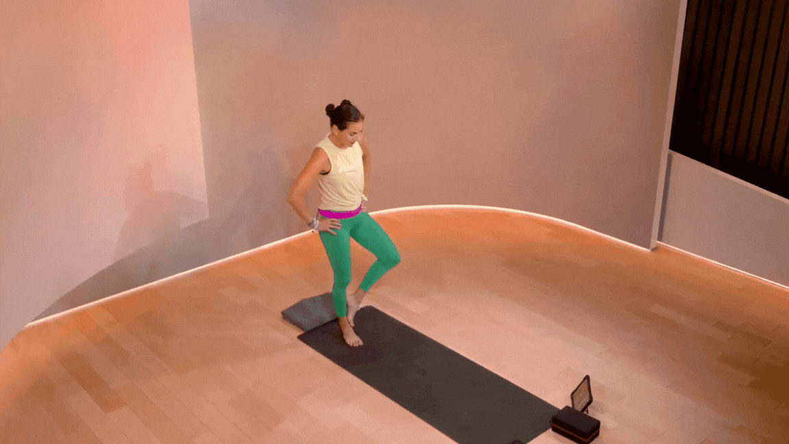 Peloton instructor Mariana Fernández demonstrates Tree Pose as a single-leg balance foot stretch during a Peloton yoga class.