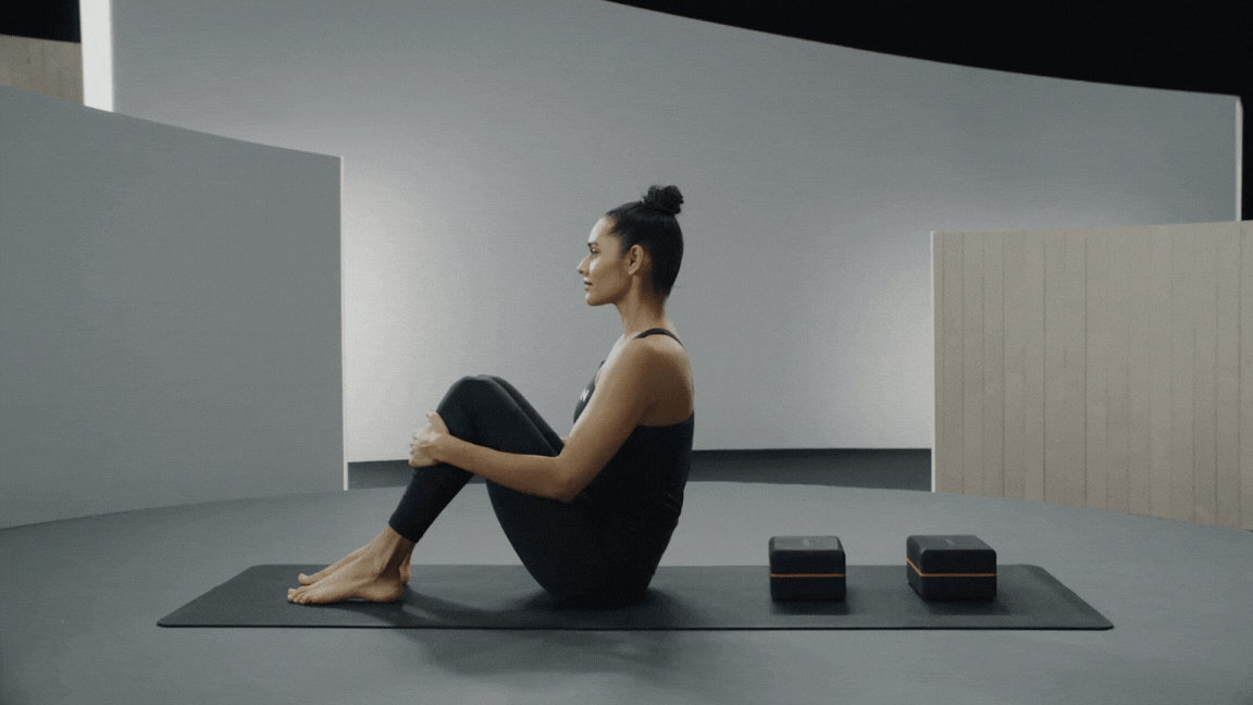 Peloton instructor Aditi Shah demonstrates supported Fish Pose in yoga.