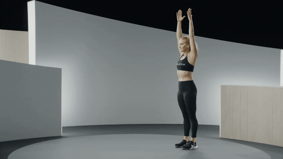 Peloton instructor Rebecca Kennedy demonstrates an inchworm workout warm-up exercise.