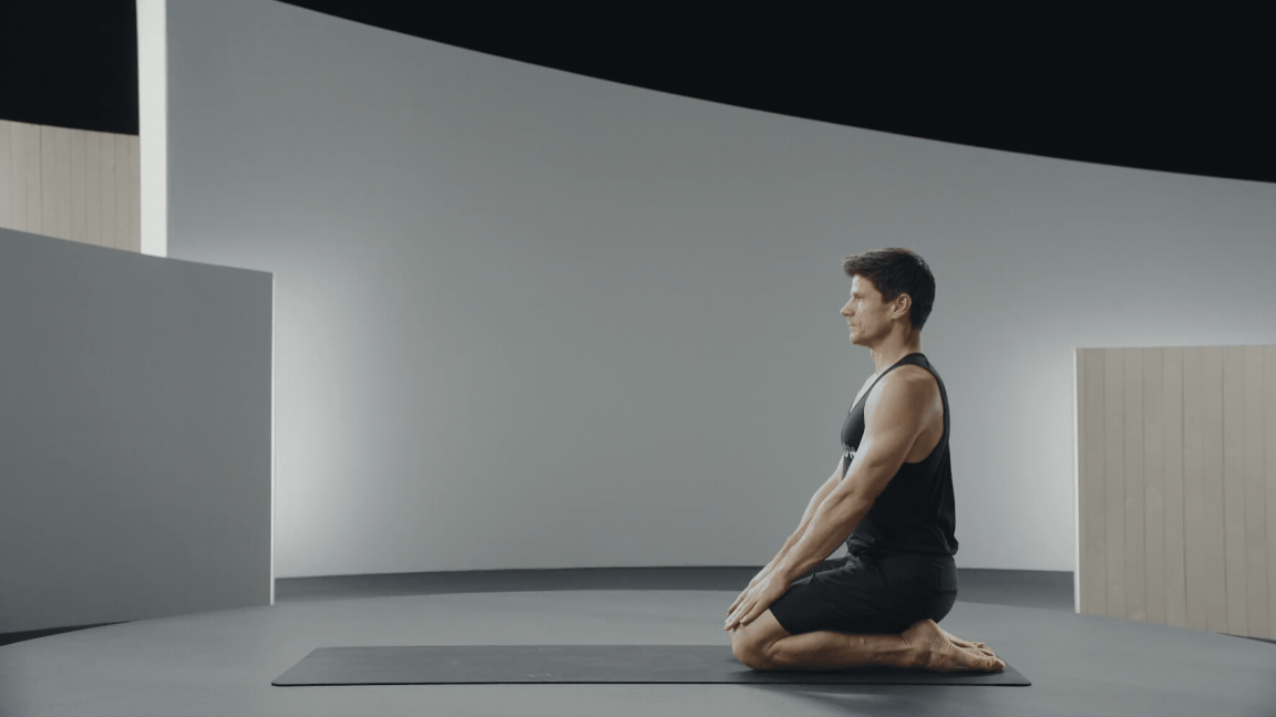 Peloton instructor Denis Morton performing Thread the Needle stretch.