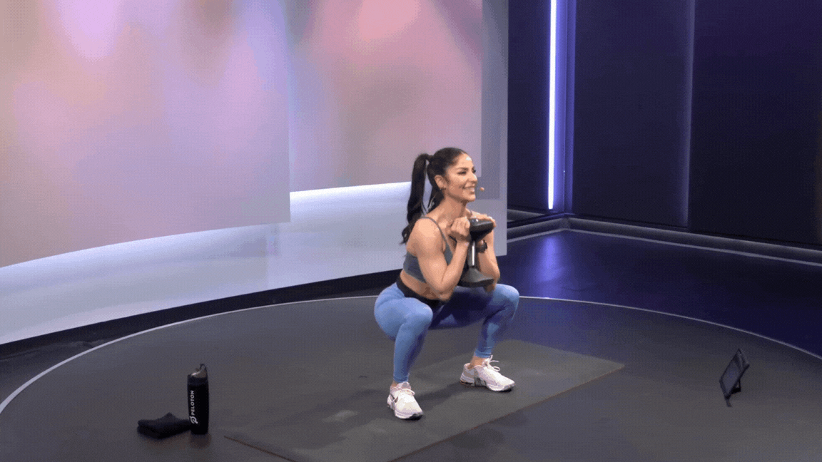 Woman demonstrates a goblet squat as a squat variation
