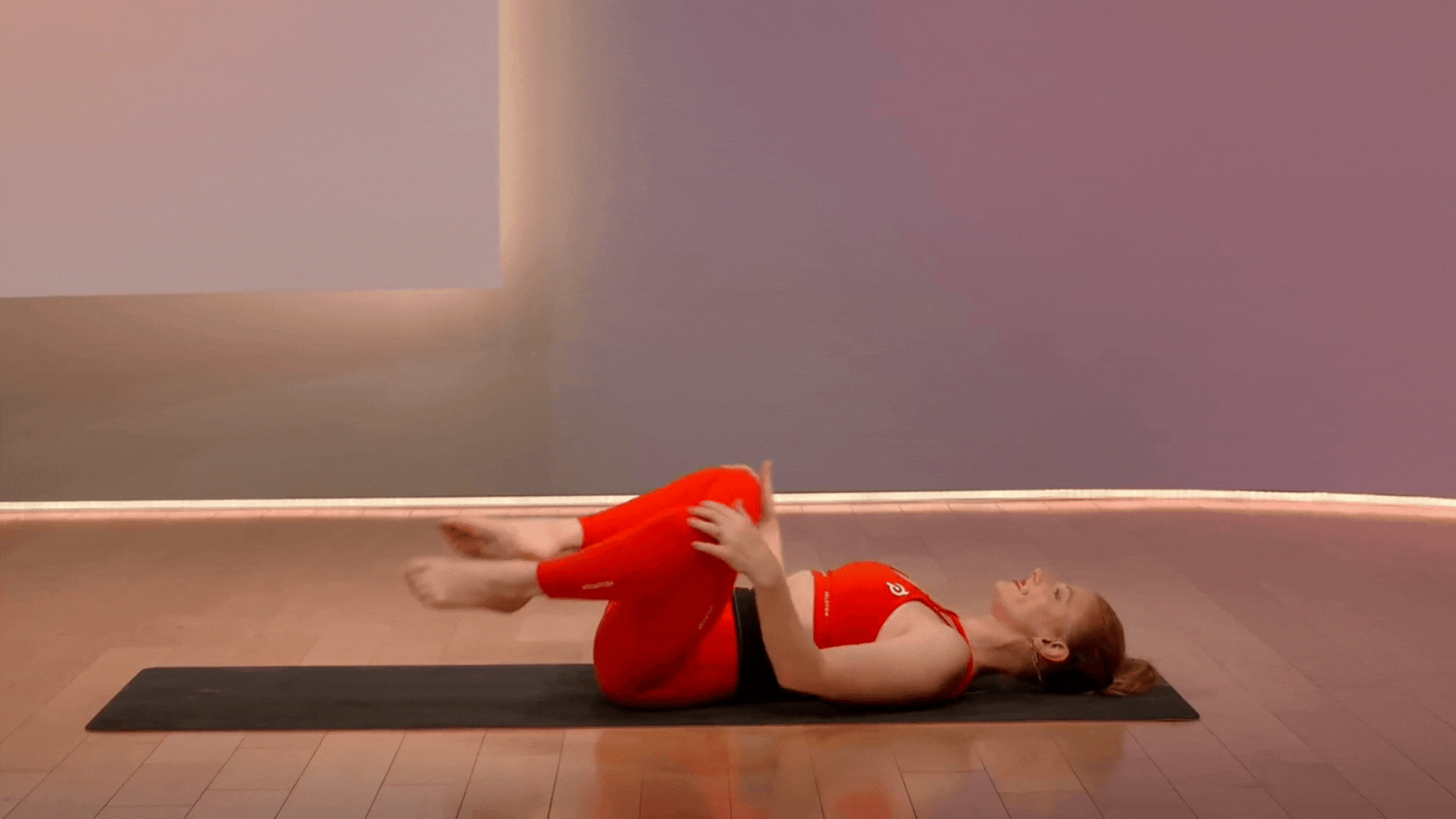Anna Greenberg doing knee stirs, a pilates mat exercise