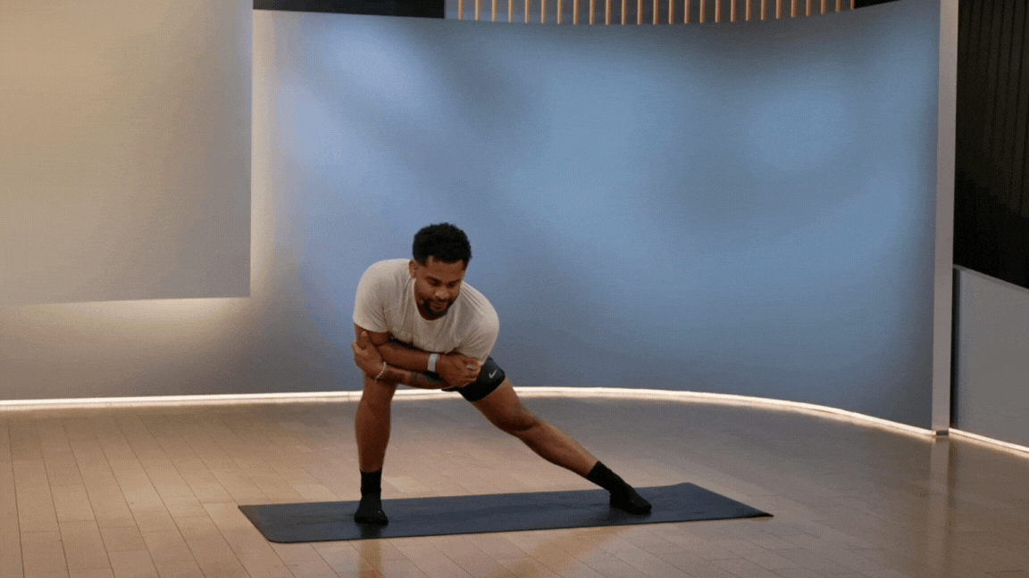 Peloton instructor Rad Lopez demonstrates a lateral lunge standing stretch during a Peloton stretch class.