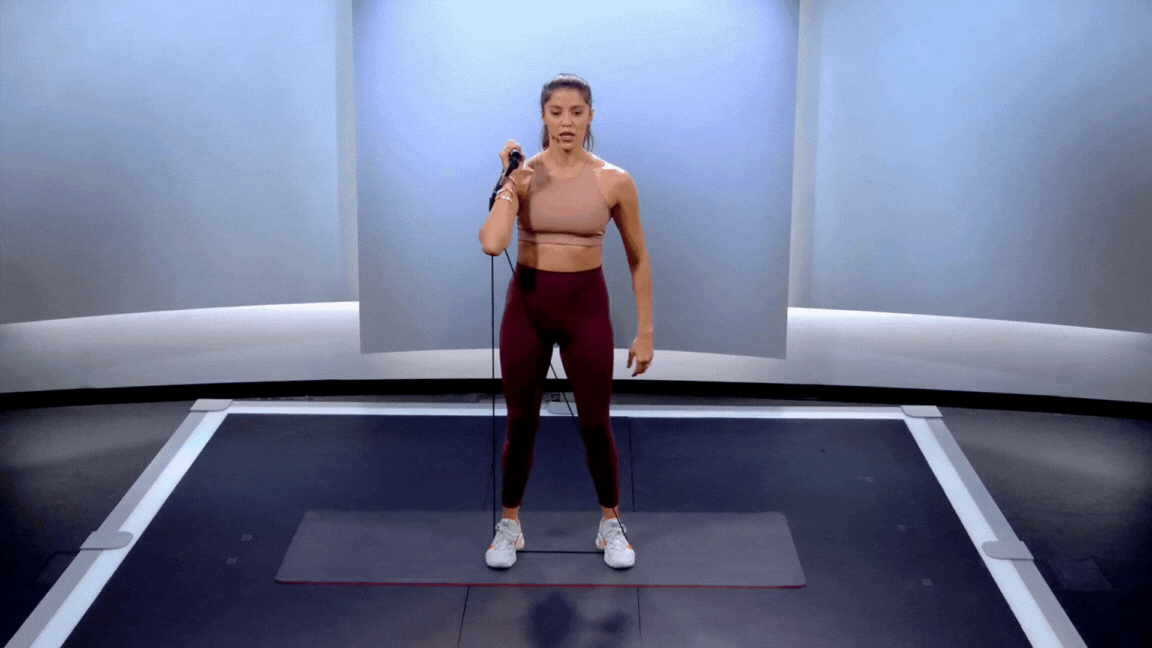 Peloton instructor Hannah Corbin demonstrates a resistance band offset squat.