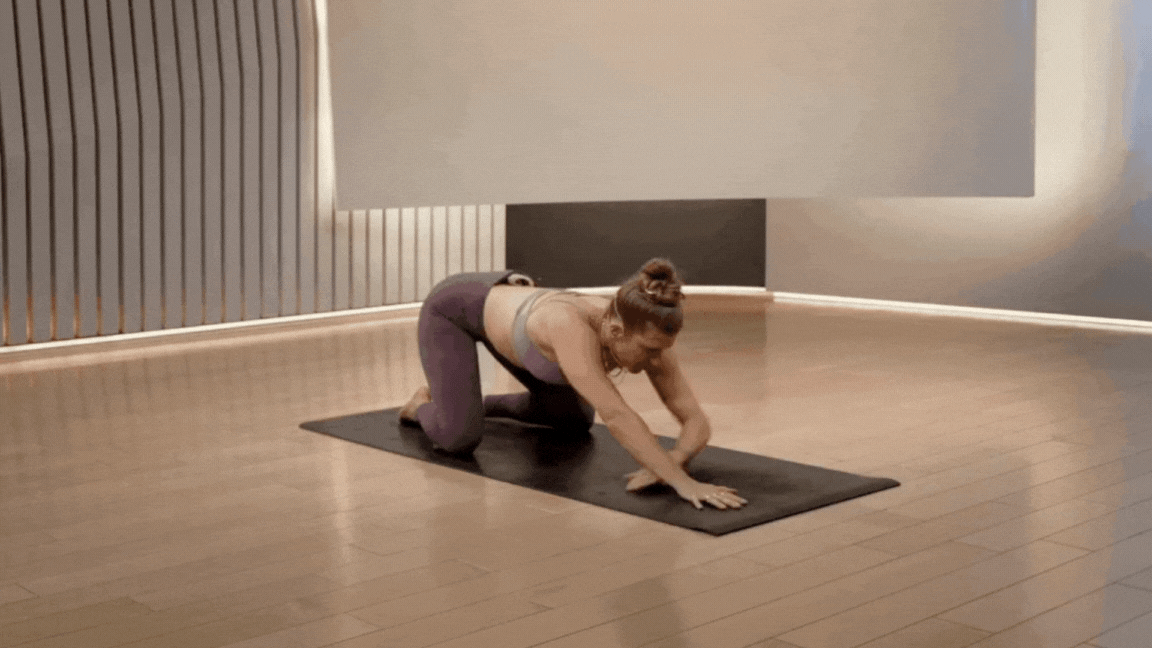 Peloton instructor Rebecca Kennedy demonstrates child's pose with a side reach as a QL stretch.