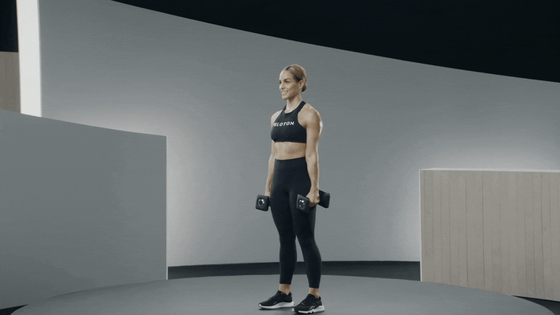 Peloton instructor Jess Sims demonstrates a dumbbell overhead press with proper form