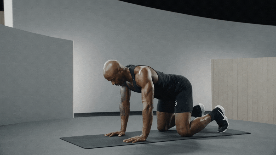 Peloton instructor Adrian Williams demonstrates a bear plank isometric exercise with proper form