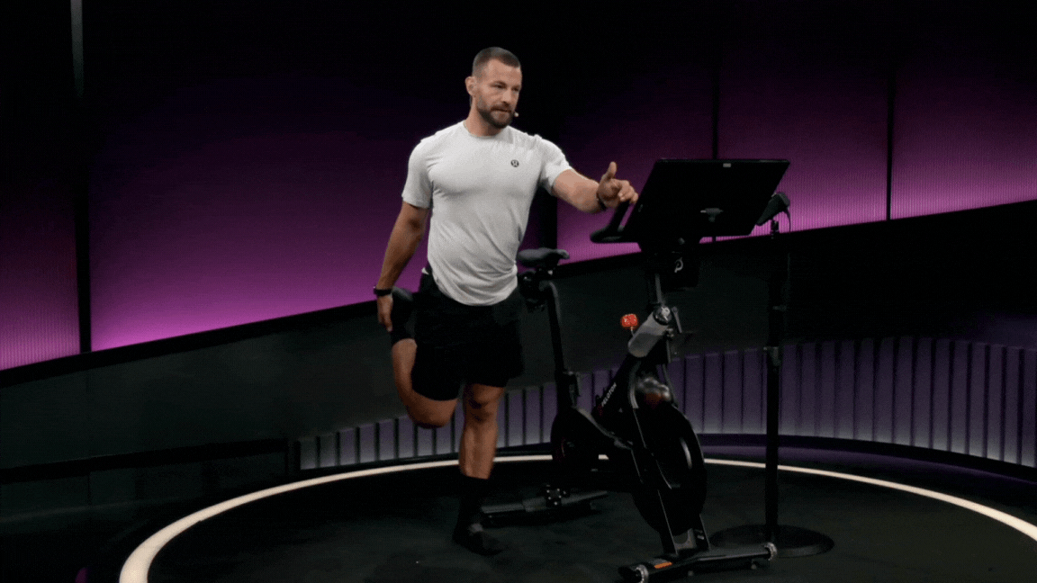 Peloton instructor Erik Jäger demonstrates a standing quad stretch during a Peloton stretch class.