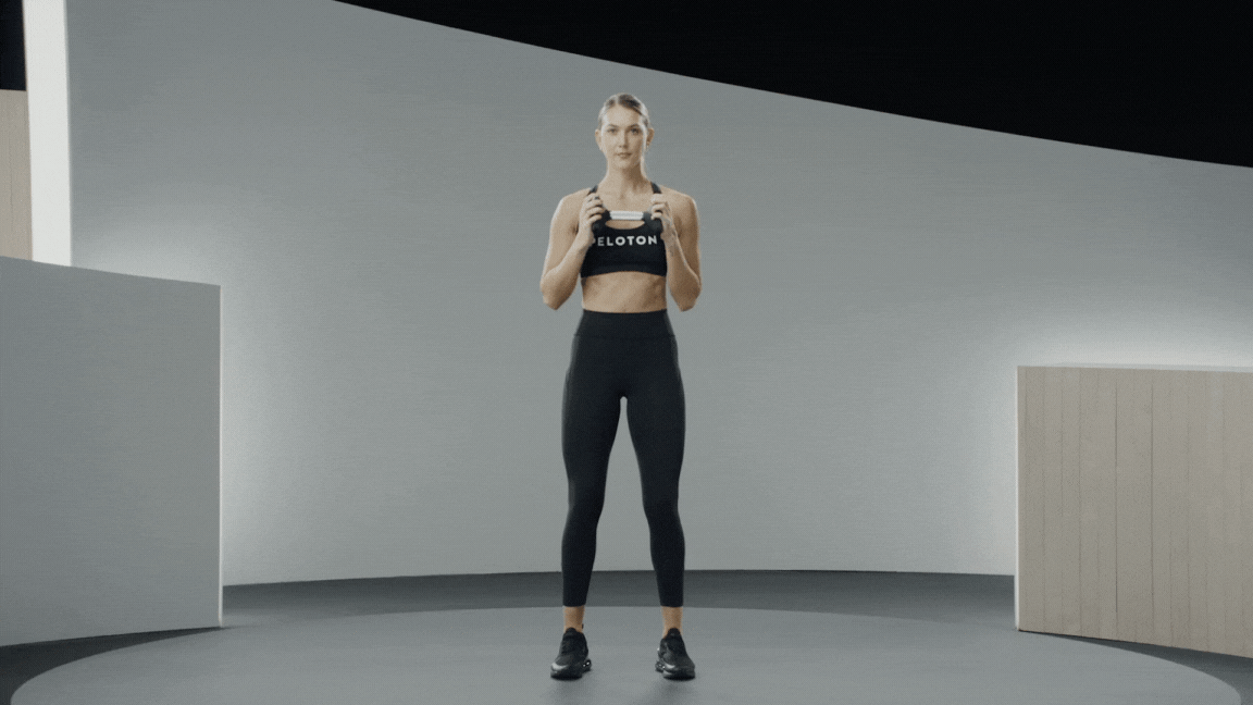 Peloton instructor Callie Gullickson demonstrates a dumbbell halo standing core exercise with proper form