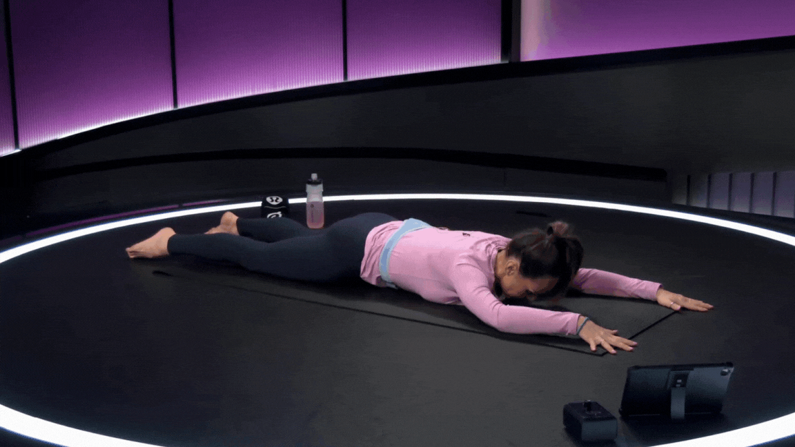 Peloton instructor Mila Lazar demonstrates swan dive prep during a Pilates class on the Peloton app