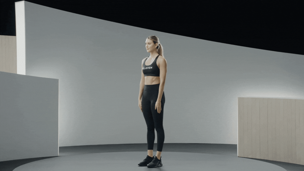 Peloton instructor Callie Gullickson demonstrates the standing dead bug core exercise with proper form 