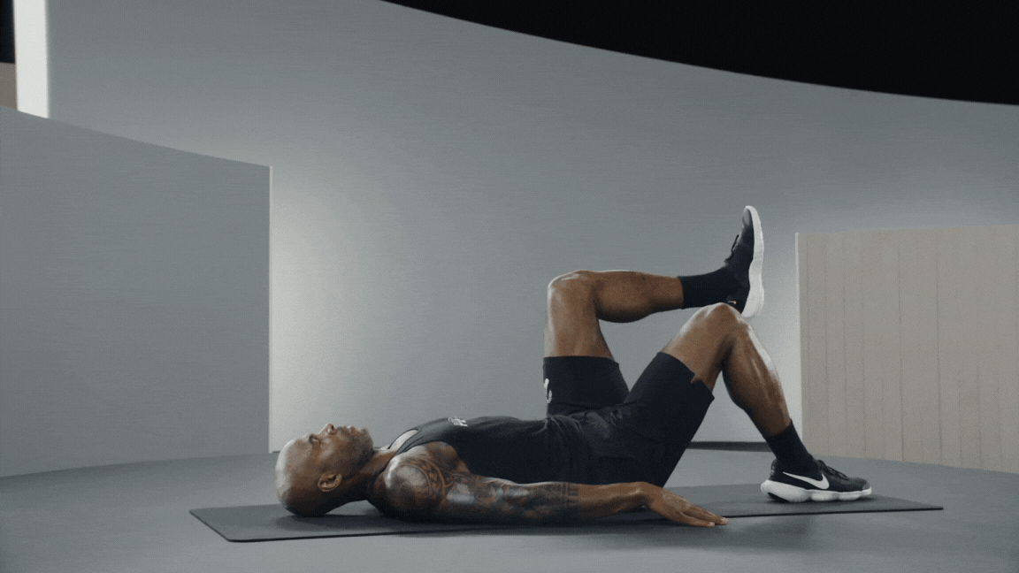 Peloton instructor Adrian Williams demonstrates a single-leg glute bridge core exercise for runners.