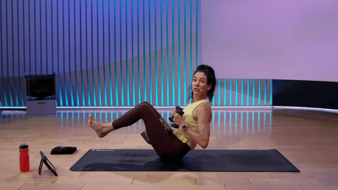 Peloton instructor Mariana Fernandez demonstrates Boat Pose with weights during a yoga class with weights.