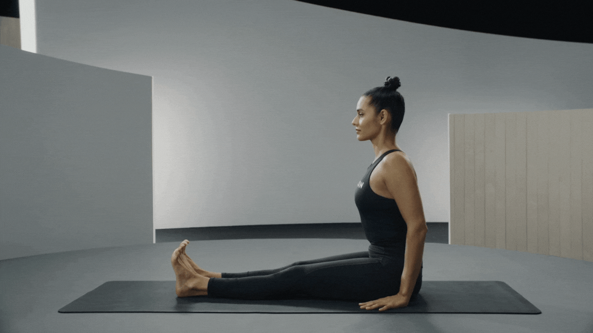 Peloton instructor Aditi Shah demonstrates Seated Forward Fold as an easy yoga pose. 