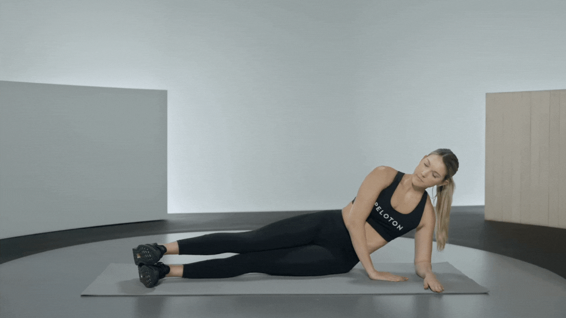 Peloton instructor Callie Gullickson demonstrates a forearm side plank rotation core exercise.