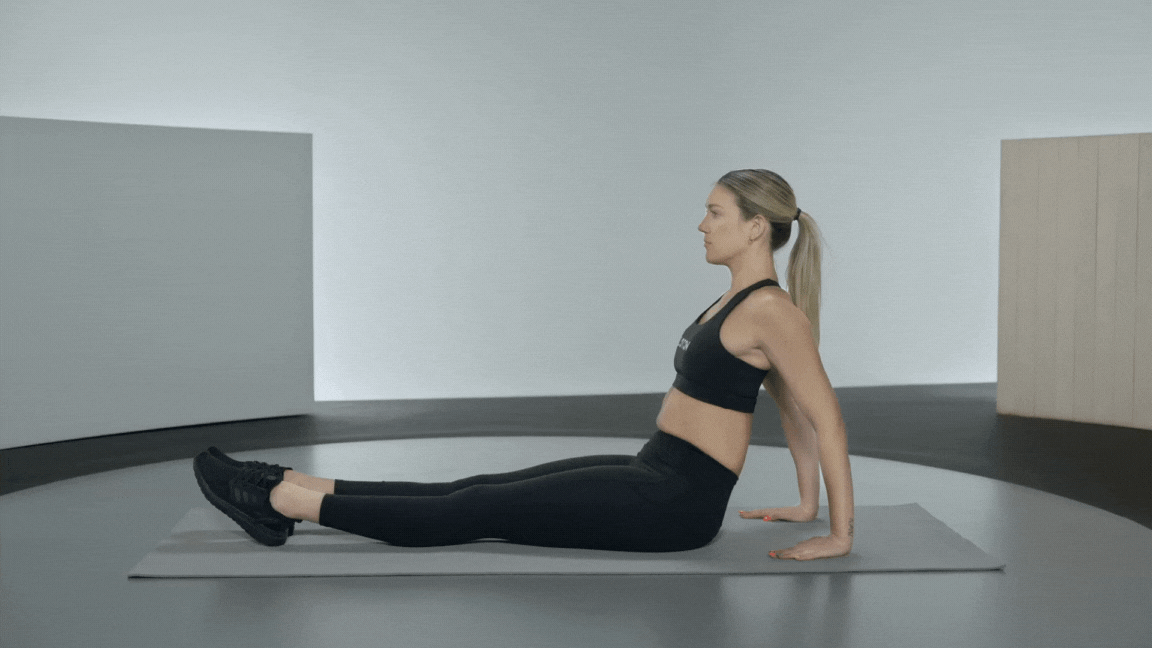 Peloton instructor Callie Gullickson demonstrates a reverse plank bodyweight back exercise.