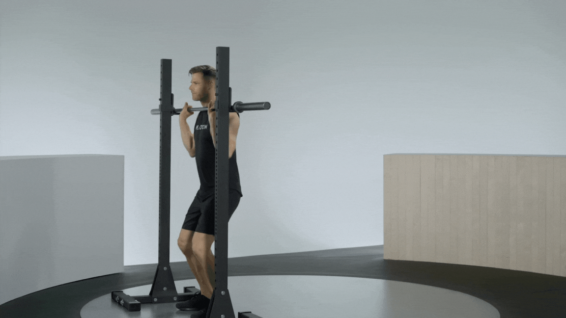 Peloton instructor Andy Speed demonstrating a barbell overhead press with proper form