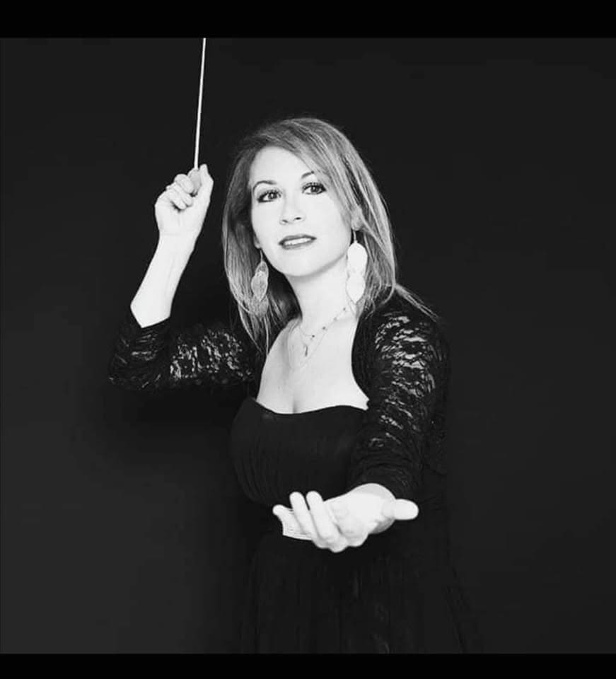 Ritratto in bianco e nero di Maria Luisa Macellaro La Franca mentre dirige con la bacchetta