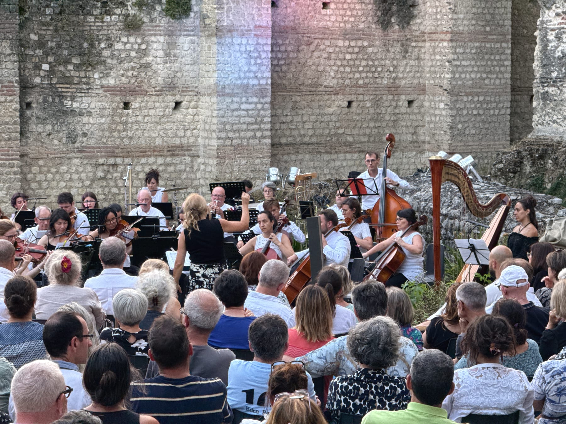 Maria Luisa Macellaro La Franca mentre dirige un’orchestra all’aperto davanti al pubblico, al Palais Gallien