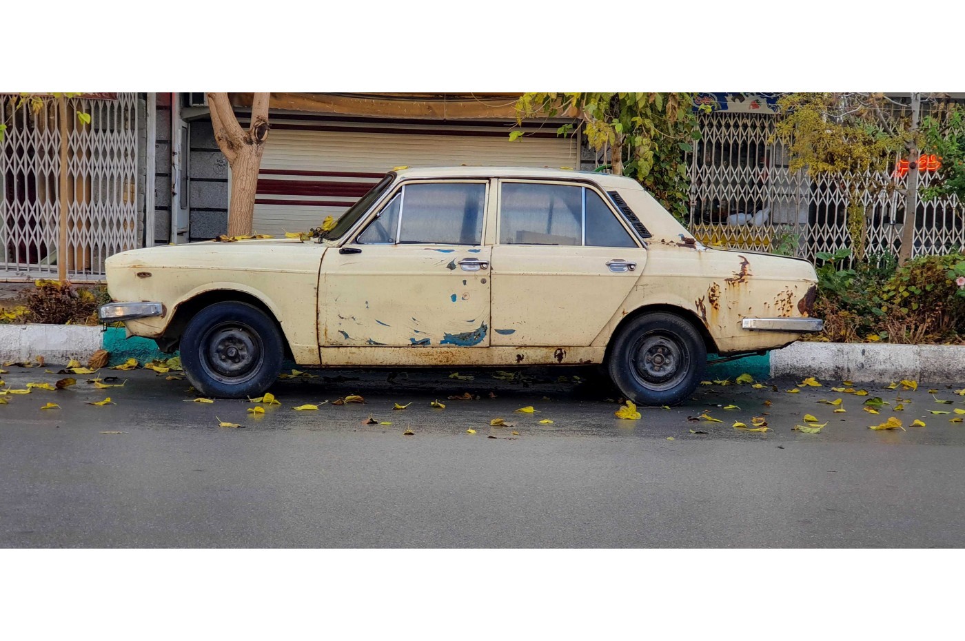 Old used car parked on a street.