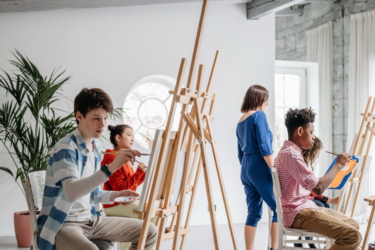 Students painting at easels in the art studio