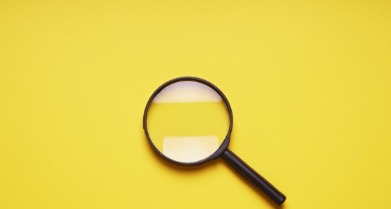 A magnifying glass on a yellow background