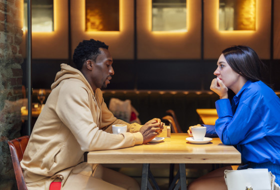 A couple have a serious conversation in a cafe