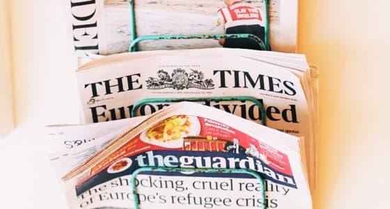 Rack of newspapers including the Guardian, Time and Independent