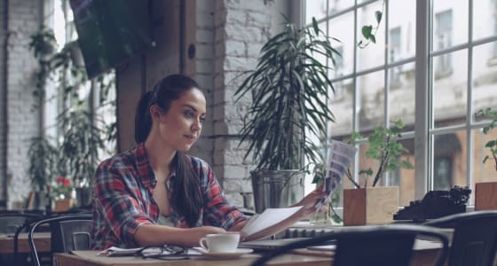 Woman in red check shirt working in a cafe