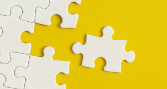 white jigsaw piece on yellow background.