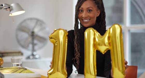 Afiya, a PensionBee customer, holding balloons.