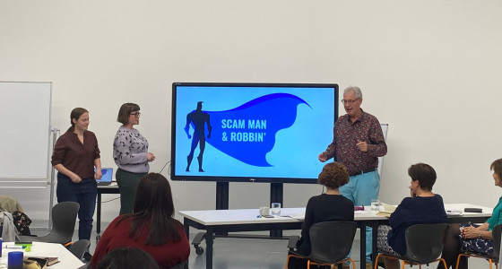 Creators of the Scam Man and Robbin presenting their game infront of whiteboard