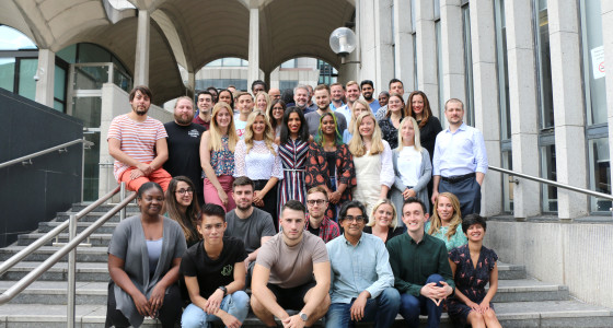 PensionBee team of over 70 people in a group photo standing outside on some steps